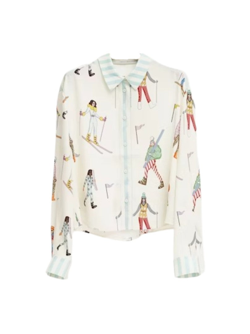 Bluse Herzensangelegenheit in weiß. Diese Seidenbluse mit Hemdkragen ist ein echtes Highlight. Sie hat eine verkürzte Länge und einen verspielten Ski-Print mit bunten Skifahrerinnen. Die Hemdbluse hat linierte Manschetten mit zwei Knöpfen und eine durchgehende Knopfleiste.