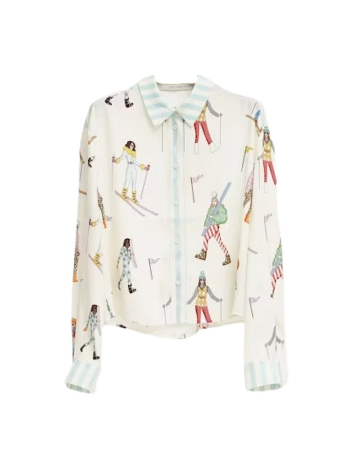 Bluse Herzensangelegenheit in weiß. Diese Seidenbluse mit Hemdkragen ist ein echtes Highlight. Sie hat eine verkürzte Länge und einen verspielten Ski-Print mit bunten Skifahrerinnen. Die Hemdbluse hat linierte Manschetten mit zwei Knöpfen und eine durchgehende Knopfleiste.