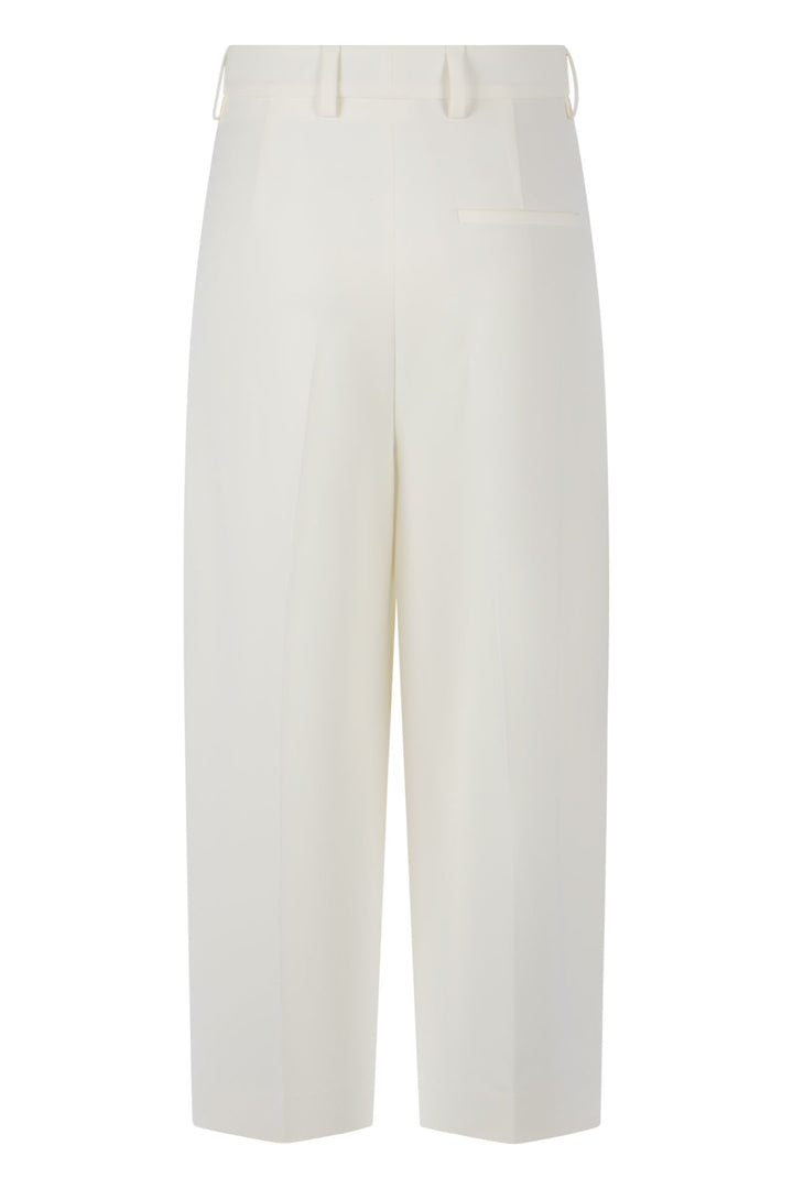 Hose Rossi Noa Crop. Coole Hose in verkürzter Form. Die Hose hat Bundfalten und einen verstellbaren Innenbund. Sie ist High-Waist geschnitten und hat ein verkürztes Bein. Der leichte O-Shape verleiht der Hose einen modernen Look. Die Hose hat schräge Eingriffstaschen und eine Leistentasche auf der Rückseite in ecru.