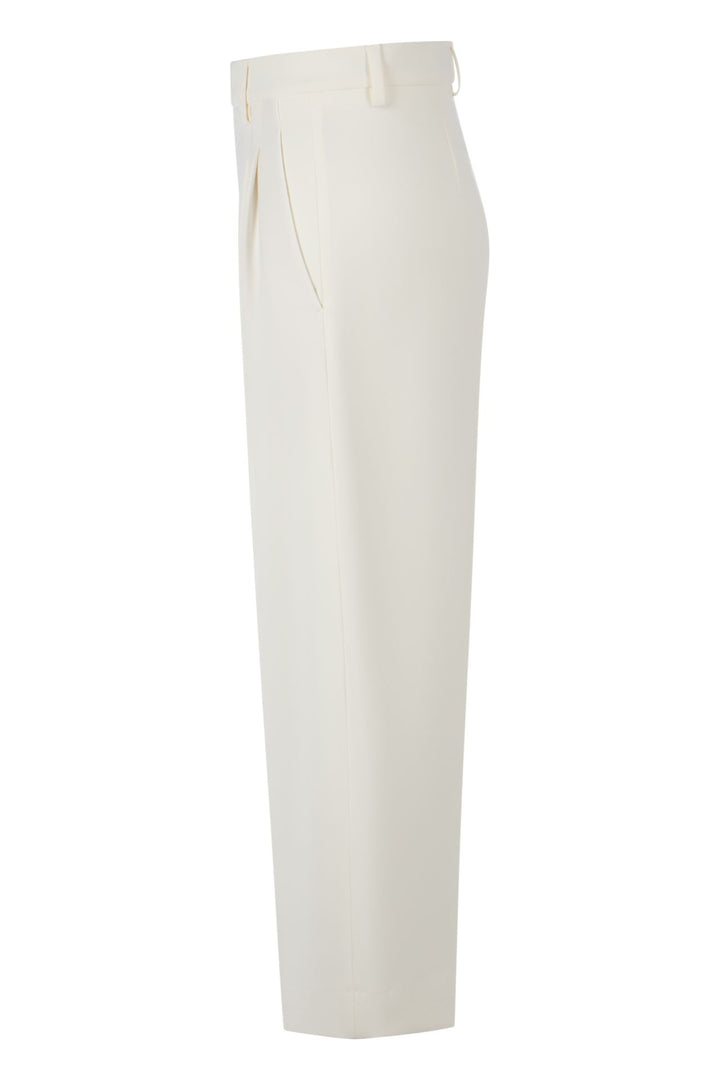 Hose Rossi Noa Crop. Coole Hose in verkürzter Form. Die Hose hat Bundfalten und einen verstellbaren Innenbund. Sie ist High-Waist geschnitten und hat ein verkürztes Bein. Der leichte O-Shape verleiht der Hose einen modernen Look. Die Hose hat schräge Eingriffstaschen und eine Leistentasche auf der Rückseite in ecru.