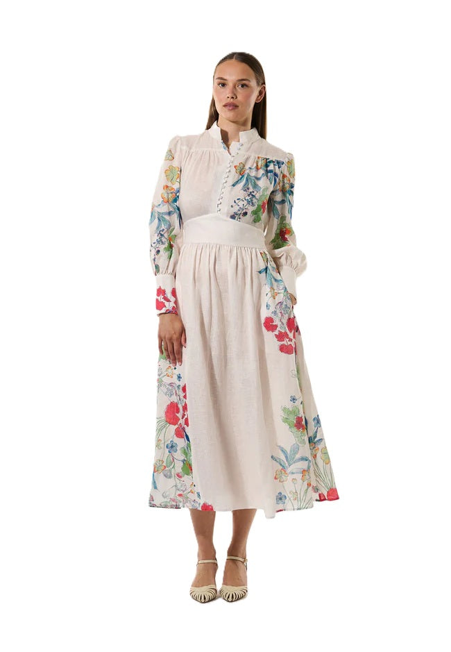 Kleid Dea Kudibal AlondraDEA hat einen Frühlingsblumenprint und einen Stehkragen, Oberteil ist figurbetont geschnitten und das Kleid hat einen Taillenbund mit  Bindegürtel in weiss mit bunten Blumen aus Leinen 