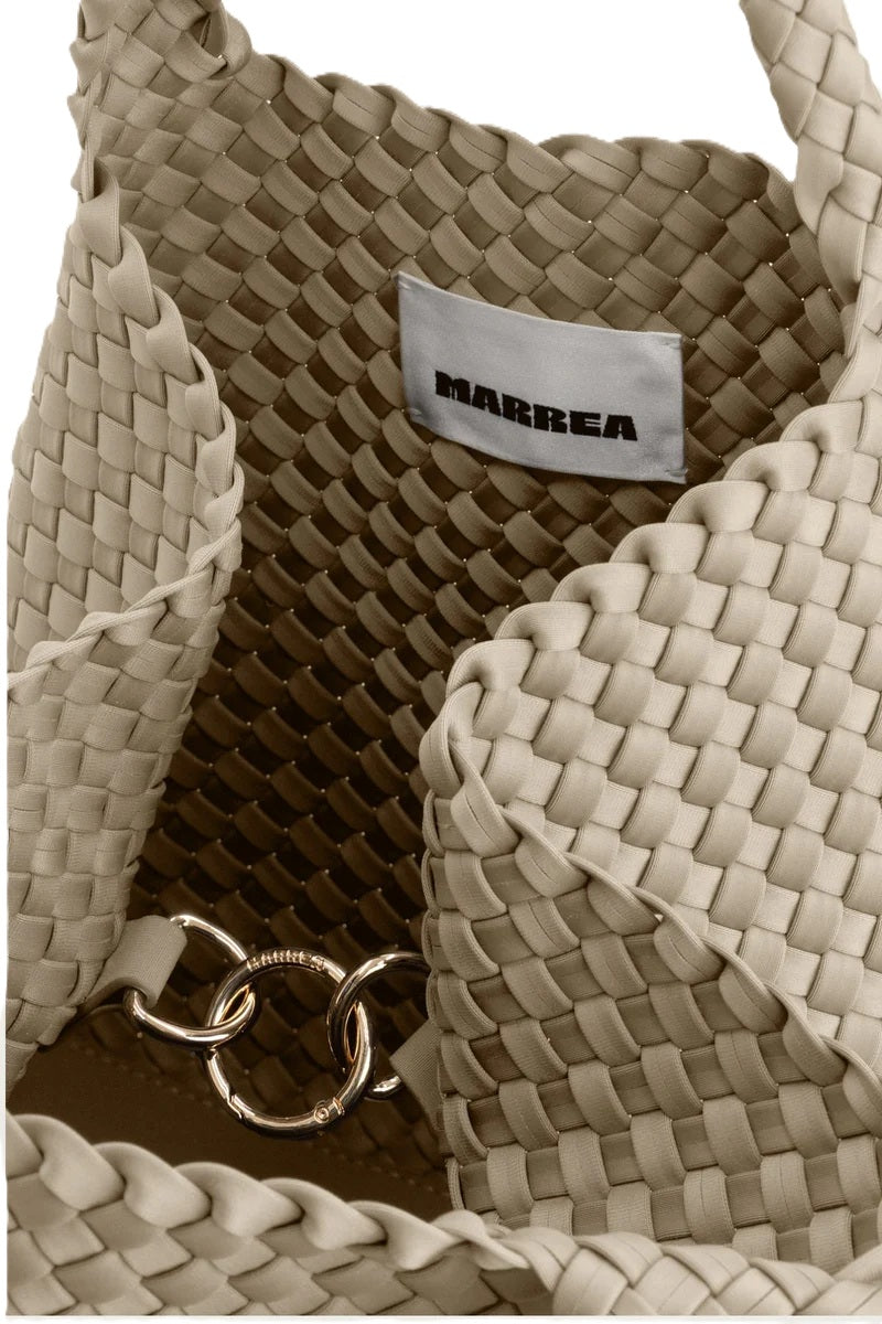 Handtasche von Marrea in gewebter Strandoptik mit zwei Griffen. Die mittelgroße Tasche ist beige mit Harken Verschluss.