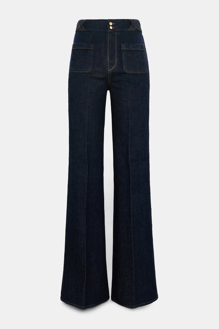 Jeans Dorothee Schumacher DENIM LOVE Pants in dark denim. Die ausgestellte dunkelblaue Jeans besticht durch ihre aufgesetzten Taschen vorne und braided Details am Bund. Dadurch bekomt die Jeans einen modernen Retro-Look. Der schmale Schnitt wird durch einen Signature-Knopf abgerundet. Die Jeans hat einen Kick und Bügelfalten. Auf der Rückseite befinden sich Pattentaschen.