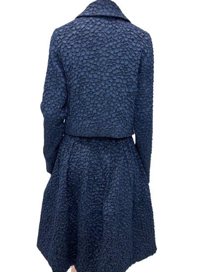 Jacke Odeeh in Nightflight. Edle Jacke aus einer genoppten Ware in dunkelblau. Die Jacke hat einen Kragen mit einem tonigen Knopf und eine verdeckte Knopfleiste. Der Kragen ist leicht abgerundet. Die Jacke hat Stecktaschen auf der Vorderseite. Sie ist körpernah geschnitten.