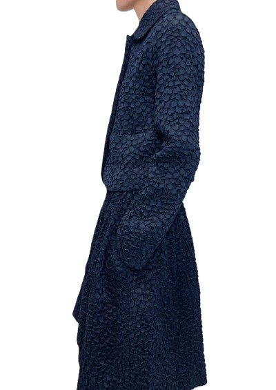 Jacke Odeeh in Nightflight. Edle Jacke aus einer genoppten Ware in dunkelblau. Die Jacke hat einen Kragen mit einem tonigen Knopf und eine verdeckte Knopfleiste. Der Kragen ist leicht abgerundet. Die Jacke hat Stecktaschen auf der Vorderseite. Sie ist körpernah geschnitten.