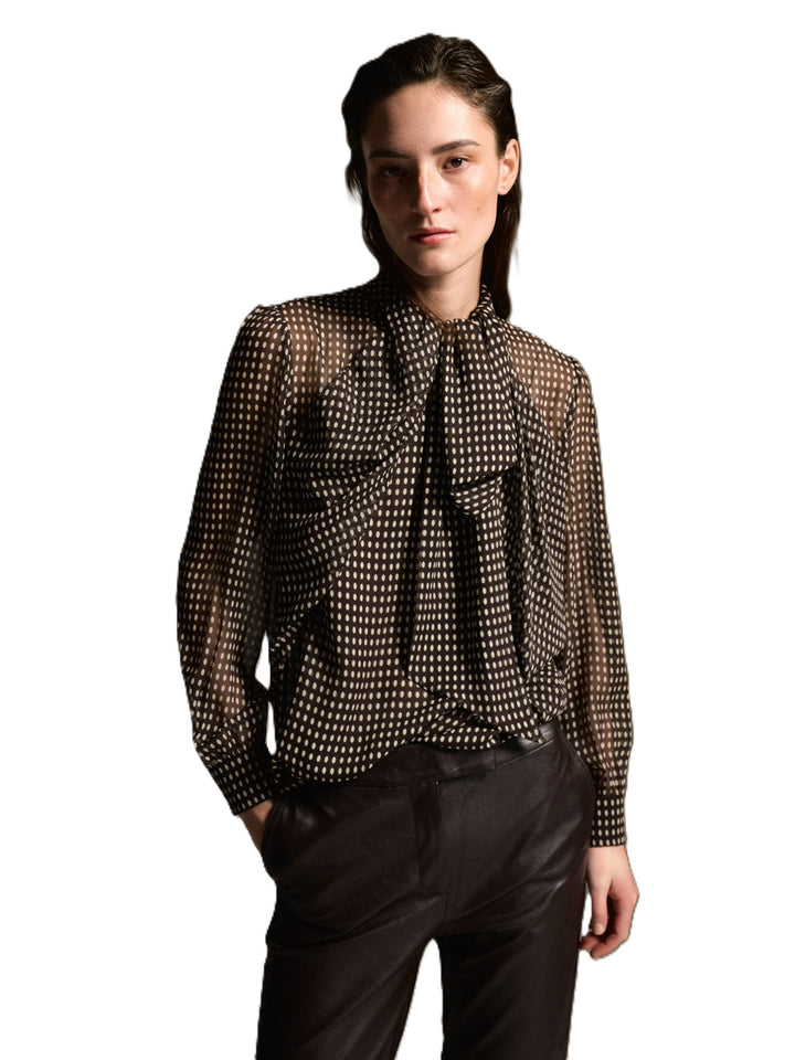 Braune Bluse Dorothea von 0039 Italy mit weißem Punktemuster, angenähter Schluppe und leicht transparenten Ärmeln.