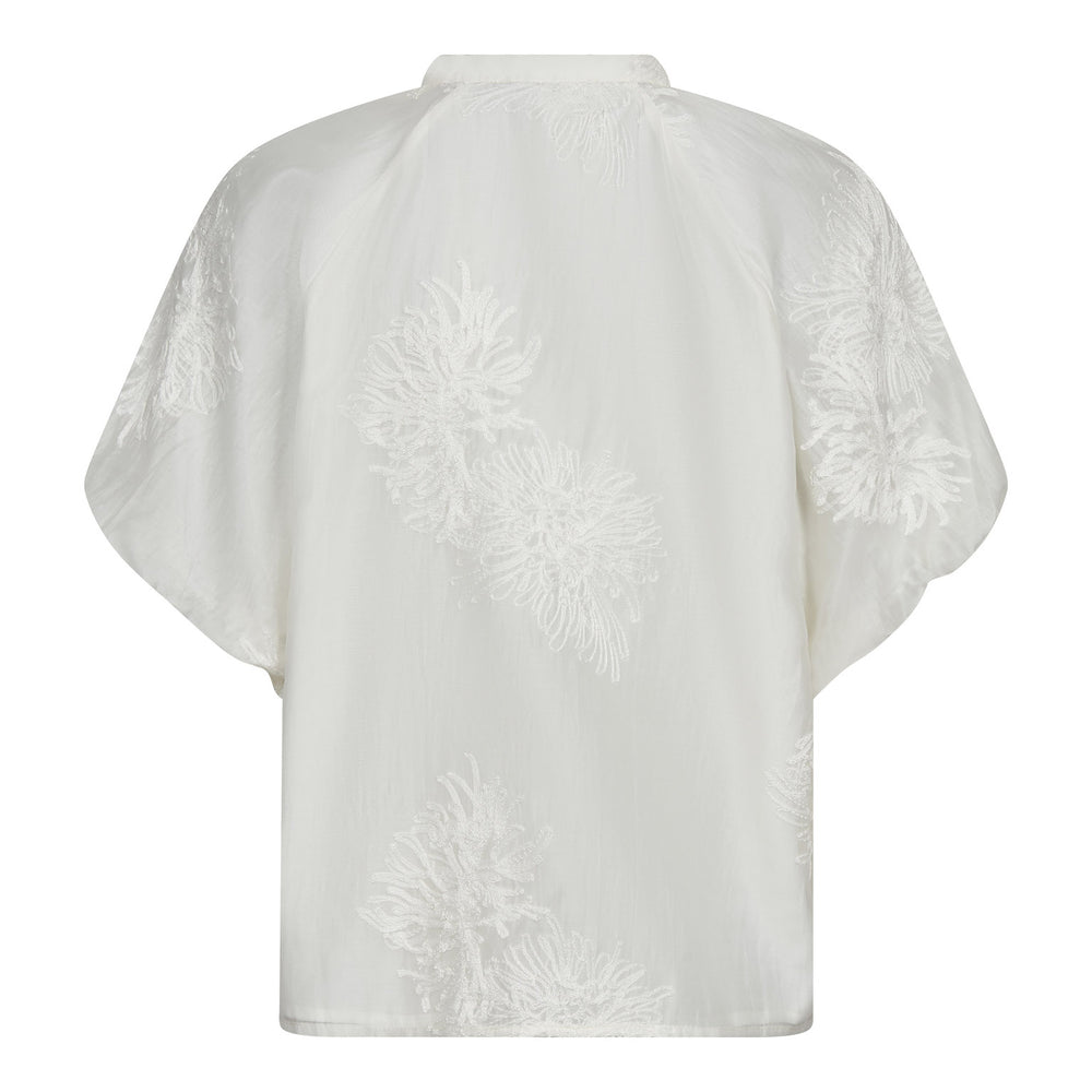 Bluse Co'Couture NeaCC SS V-Shirt in weiß. Super hübsche Bluse in weiß mit aufgestickten Blumenapplikationen. Die Bluse hat einen V-Ausschnitt und eine Knopfleiste mit farblich passenden überzogenen Knöpfen. Die Bluse hat einen Stehkragen und einen überschnittenen weiteren Ärmel mit Gummibund am Saum. Die Bluse hat eine gerade Form