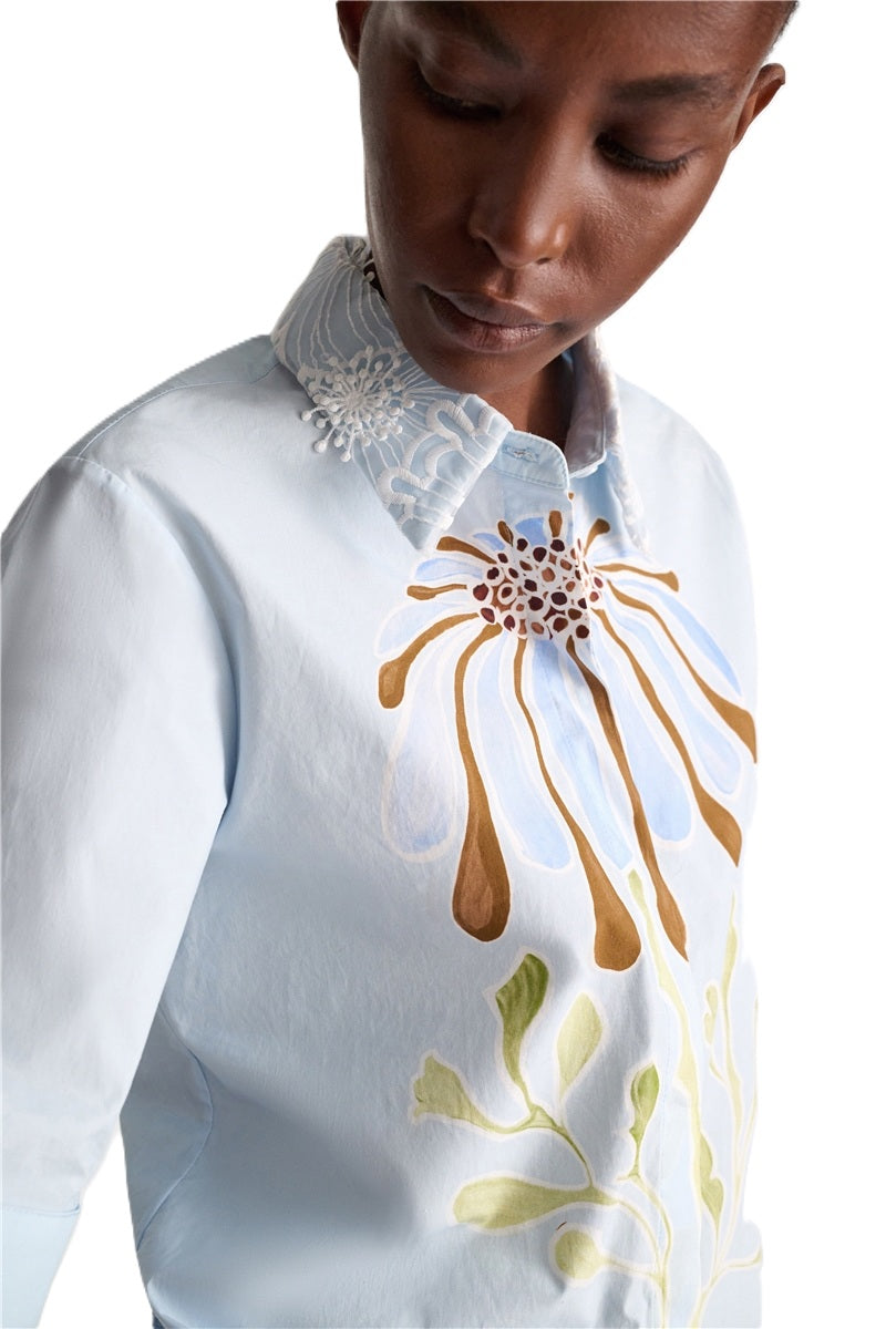 Bluse von Dorothee Schumacher Floral Power Blouse in hellblau mit weißem Spitzenkragen. Die Bluse hat einen Blumendruck und eine Knopfleiste. Wir habe auch den passenden Rock dazu. 