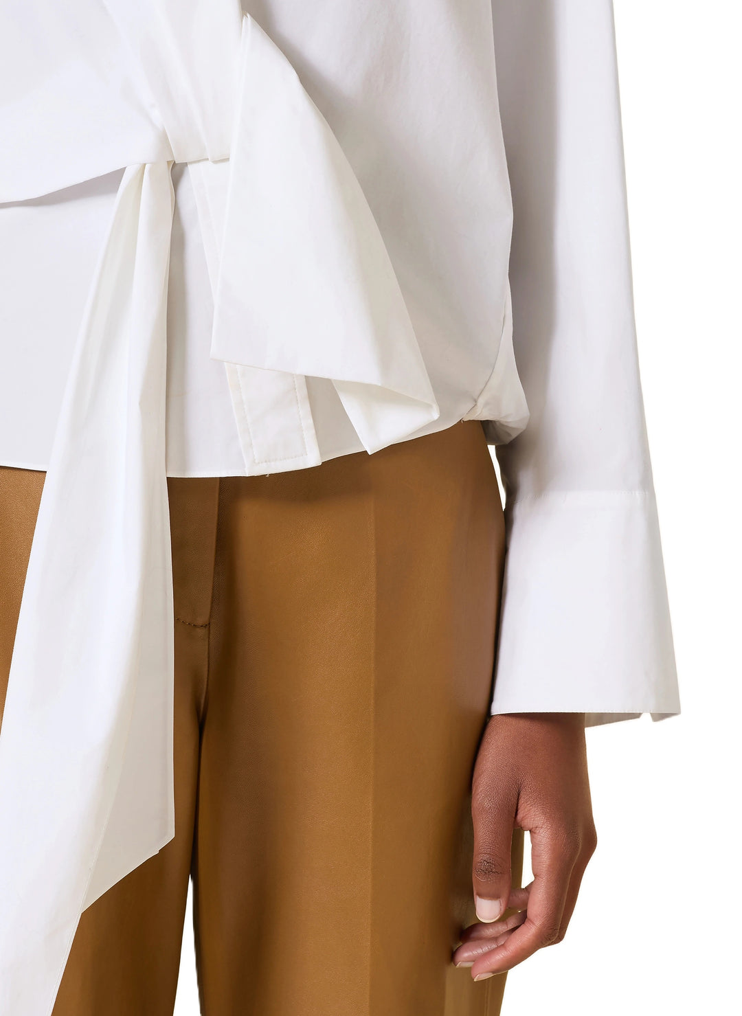 Bluse Dorothee Schumacher POPLIN POWER blouse in weiß. Diese Bluse ist ein richtiges It-Piece. Sie vereint modische Wickeloptik mit femininem Schnitt perfekt. Die Bluse hat einen Schalkragen und lange Ärmel. An den Manschetten befinden sich schöne Knöpfe. Die Ärmel sind weit und die Schultern überschnitten. Auf der Rückseite ist die Bluse eingeschlagen und der Saum mit einem elastischen Band versehen.