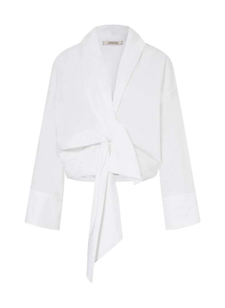 Bluse Dorothee Schumacher POPLIN POWER blouse in weiß. Diese Bluse ist ein richtiges It-Piece. Sie vereint modische Wickeloptik mit femininem Schnitt perfekt. Die Bluse hat einen Schalkragen und lange Ärmel. An den Manschetten befinden sich schöne Knöpfe. Die Ärmel sind weit und die Schultern überschnitten. Auf der Rückseite ist die Bluse eingeschlagen und der Saum mit einem elastischen Band versehen.