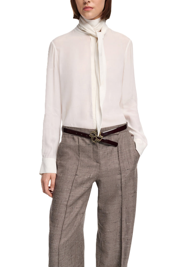 Bluse Dorothee Schumacher Soft Vibes in ecru. Schön fallende Seidenbluse mit eleganten Schal. Die Bluse hat eine verdeckte Knopfleiste und breite Manschetten. Sie hat eine lockere Passform und fällt größengerecht aus.