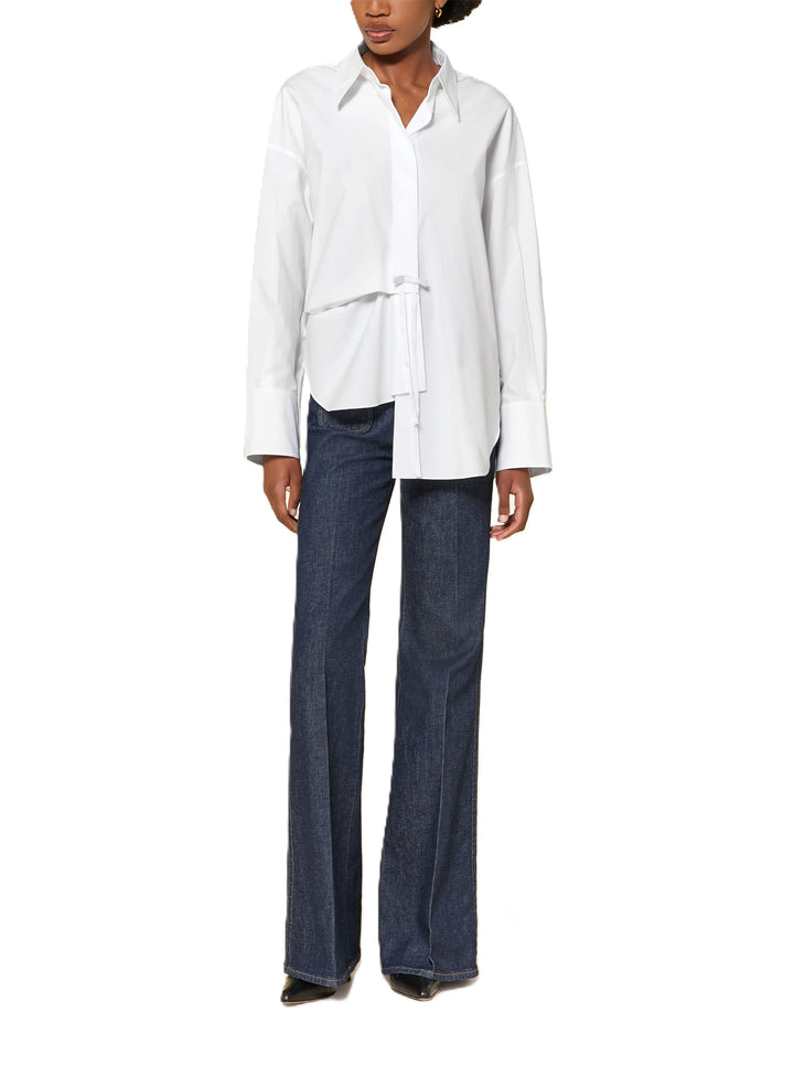 Bluse Dorothee Schumacher POPLIN POWER blouse in weiß. Sportliche Bluse von Dorothee Schumacher in weiß. Die Bluse ist länger und gerade geschnitten mit Schlitzen an den Seiten. Sie hat einen Hemdblusenkragen und eine verdeckte Knopfleiste. An den Manschetten befinden sich Knöpfe, auf der Rückseite eine Quetschfalte. Auf der Vorderseite befindet sich ein hübsches Schleifendetail und die Bluse ist asymmetrisch geschnitten.