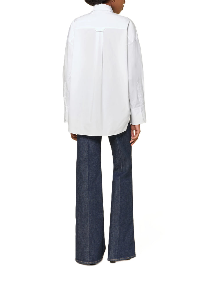 Bluse Dorothee Schumacher POPLIN POWER blouse in weiß. Sportliche Bluse von Dorothee Schumacher in weiß. Die Bluse ist länger und gerade geschnitten mit Schlitzen an den Seiten. Sie hat einen Hemdblusenkragen und eine verdeckte Knopfleiste. An den Manschetten befinden sich Knöpfe, auf der Rückseite eine Quetschfalte. Auf der Vorderseite befindet sich ein hübsches Schleifendetail und die Bluse ist asymmetrisch geschnitten.