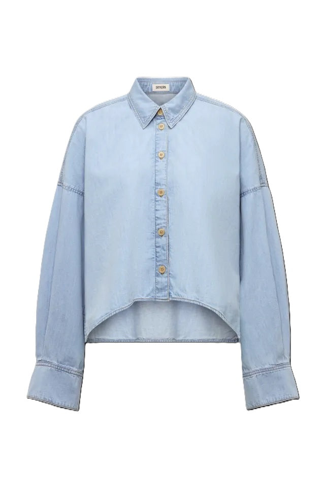 Bluse Drykorn OSHIA 10 in blau. OSHIA ist eine weit geschnittene Hemdbluse mit überschnittener Schulter und überlangen Ärmeln. Der Indigo Denim hat eine helle Farbgebung und einen leichten Wascheffekt was ihn zu einem echten Everyday Essential macht. Die Bluse hat einen Kragen und eine verdeckte Knopfleiste und ist vorne kürzer geschnitten als hinten.