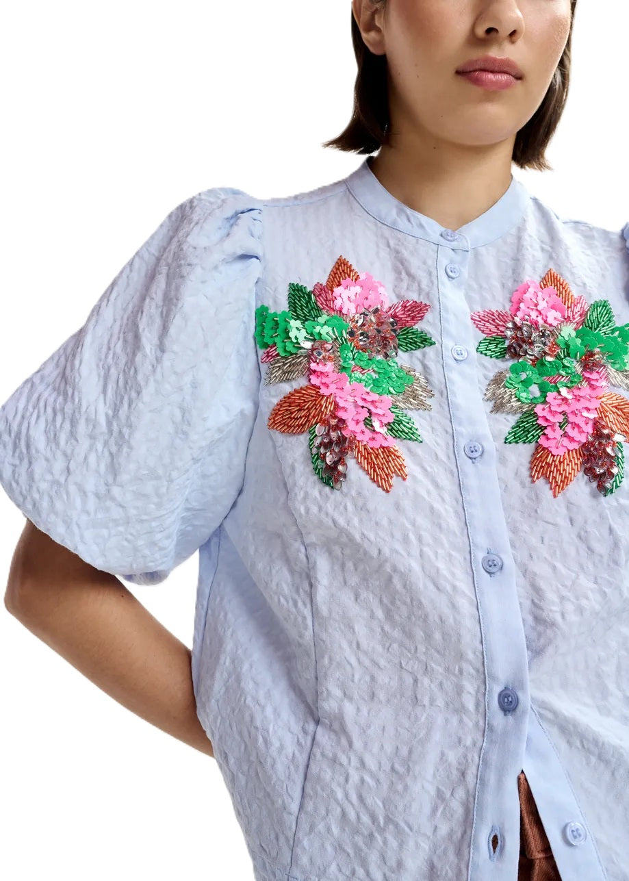 Bluse von Essentiel Antwerp Jaiden in hellblau mit bunter Blumenstickerei aus Pailletten. Halbarm mit Gummimanschette. 