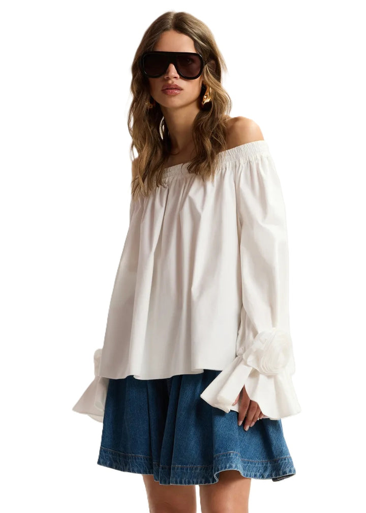 Shirt Essentiel Antwerp JOFIE OFF SHOULDER TOP in weiß. Das weiße trägerlose Shirt ist aus 100% Baumwolle gefertigt und hat eine weite Silhouette. Der elastische Ausschnitt sorgt für guten Halt, während der ausgestellte Saum das Shirt locker fallen lässt. Das Shirt hat am Ärmelsaum wunderschöne Rosettenverzierungen. 