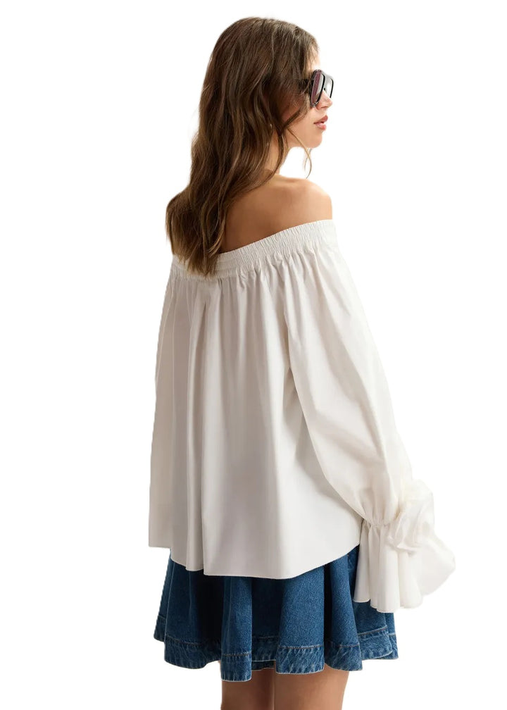 Shirt Essentiel Antwerp JOFIE OFF SHOULDER TOP in weiß. Das weiße trägerlose Shirt ist aus 100% Baumwolle gefertigt und hat eine weite Silhouette. Der elastische Ausschnitt sorgt für guten Halt, während der ausgestellte Saum das Shirt locker fallen lässt. Das Shirt hat am Ärmelsaum wunderschöne Rosettenverzierungen. 