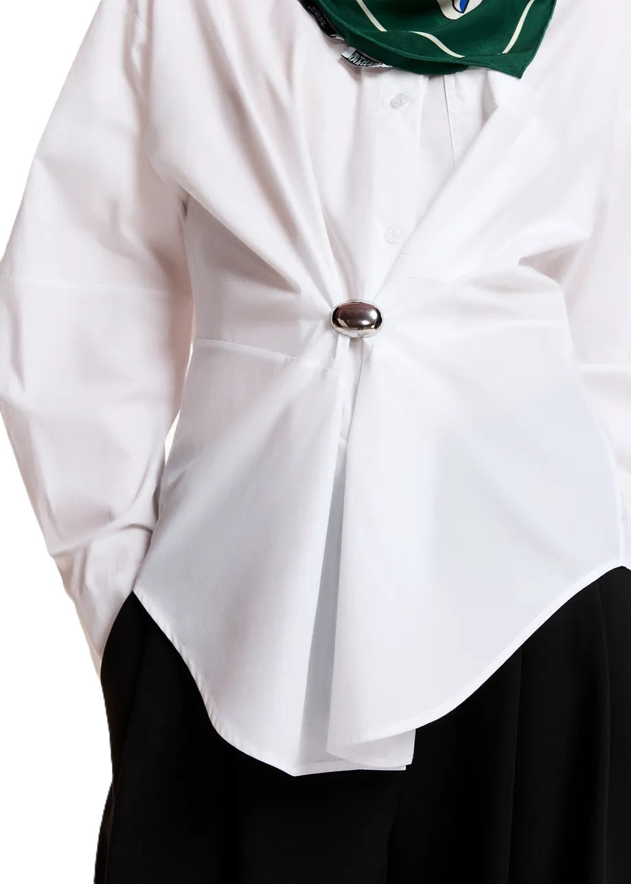 Bluse Essentiel Antwerp KREATIVE OVERSIZED SHIRT in weiß. Das Hemd aus Bio-Baumwolle besticht durch eine großzügige Silhouette mit einer sanft abgerundeten Naht. Die Bluse hat einen Hemdkragen und eine Brusttasche. Sie hat tief angesetzte Schultern und leicht voluminöse Ärmel. Abgerundet wird das Design mit geknöpften Manschetten und einer abnehmbaren Brosche. 