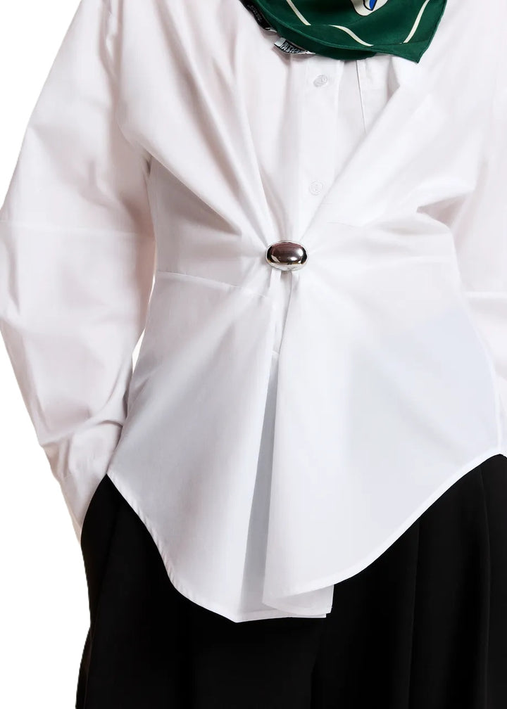 Bluse Essentiel Antwerp KREATIVE OVERSIZED SHIRT in weiß. Das Hemd aus Bio-Baumwolle besticht durch eine großzügige Silhouette mit einer sanft abgerundeten Naht. Die Bluse hat einen Hemdkragen und eine Brusttasche. Sie hat tief angesetzte Schultern und leicht voluminöse Ärmel. Abgerundet wird das Design mit geknöpften Manschetten und einer abnehmbaren Brosche. 