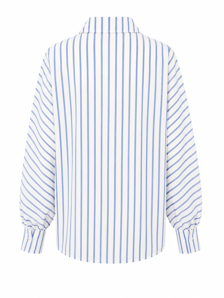 Bluse Herzens. Schöne Bluse aus Baumwolle von Herzens in weiß mit blauem Streifen. Die Bluse hat einen schönen Raglanärmel und einen Kragen. Knopfleiste auf der Vorderseite. Sie hat schöne große Manschetten mit Knopf.