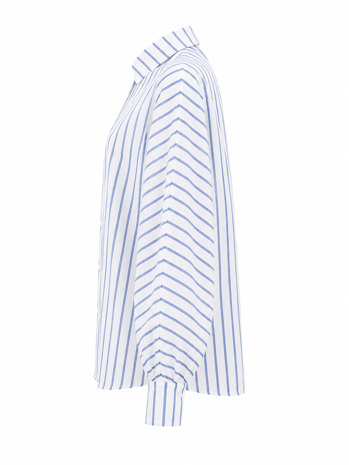 Bluse Herzens. Schöne Bluse aus Baumwolle von Herzens in weiß mit blauem Streifen. Die Bluse hat einen schönen Raglanärmel und einen Kragen. Knopfleiste auf der Vorderseite. Sie hat schöne große Manschetten mit Knopf.