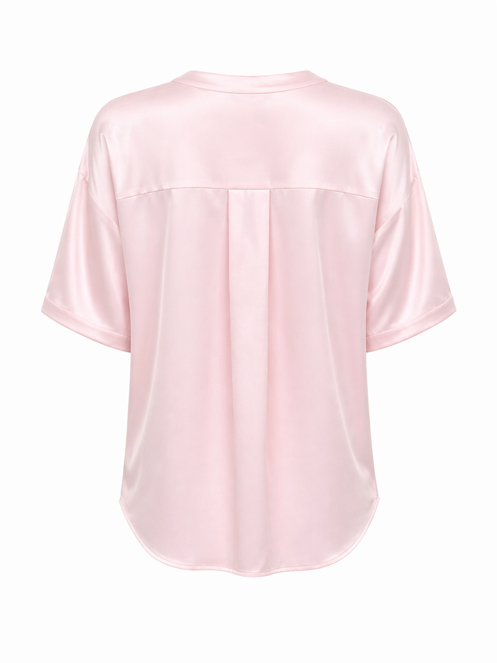 Rosa Seidenbluse in glänzender Qualität mit kurzen Ärmeln und Knopfleise.
