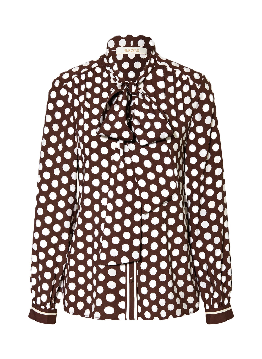 Bluse Herzens. Schöne feminine Bluse mit Pünktchenmuster in braun weiß. Die Bluse hat eine Schluppe und schöne überzogene Knöpfe. Auch an den Manschetten sind die Knöpfe farblich passend überzogen. Die Ärmel sind lang und die Form gerade. An der Vorderseite sind leichte Falten eingearbeitet.