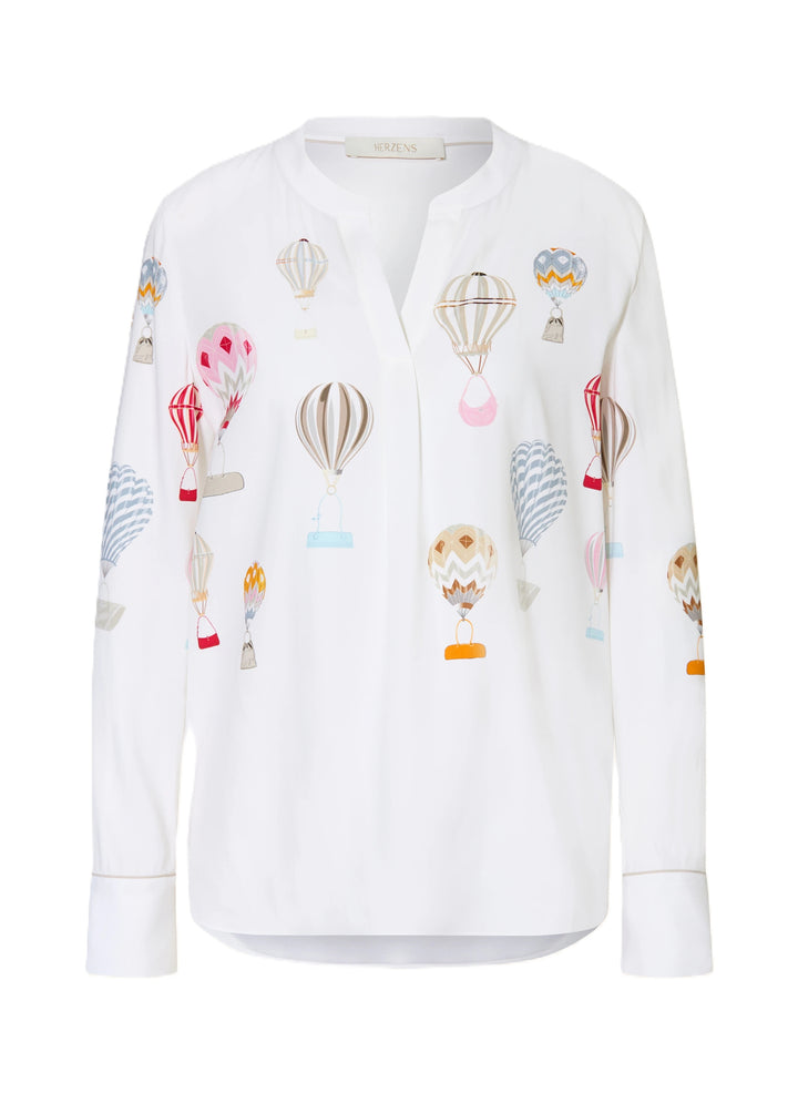 Bluse Herzens. Feminine Seidenbluse in weiß mit bunten Ballons. Die Bluse hat einen Tunikaausschnitt und einen Stehkragen. Sie hat lange Ärmel. Die Form ist gerade. Sie hat&amp;nbsp;Zweiknopf-Manschetten und eine verlängerte Rückenpartie.