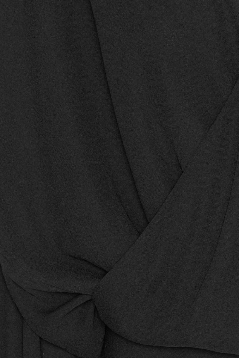 Bluse Rotate in schwarz. Die Bluse hat einen femininen V-Ausschnitt und überzeugt durch eine drapierte Wickeloptik vorne und gerafften Schultern. Die Bluse hat lange Ärmel mit breiten Manschetten. Die Bluse hat eine weiche Textur und einen eleganten Fall. Sie fällt groß aus.