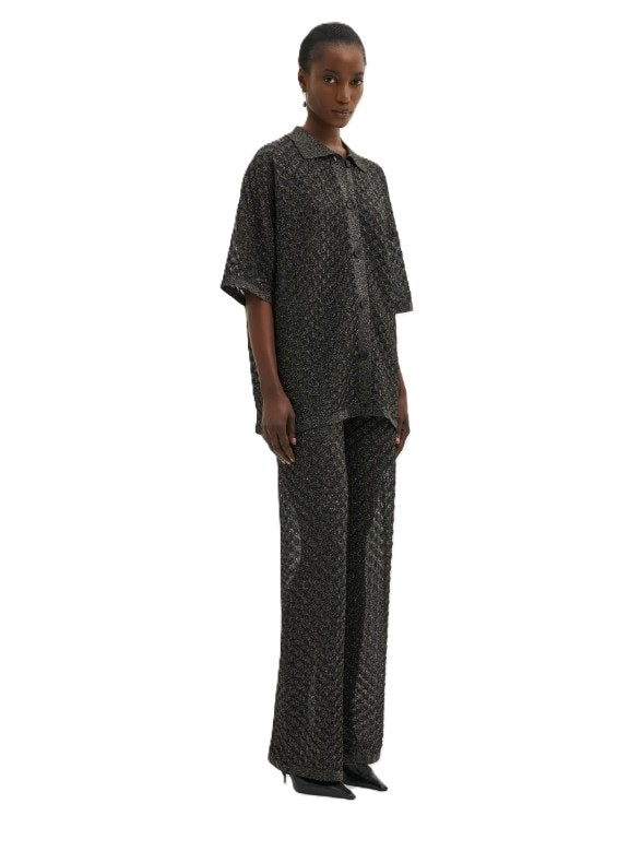 Bluse Malina Moa Oversized Pointelle Knitted Shirt in schwarz. Kurzarm-Strickhemd mit filigranem Muster. Das Hemd hat einen metallischen Schimmer in schwarz und ist aus Feinstrick gewebt. Es hat eine Knopfleiste auf der Vorderseite und einen Kragen.
