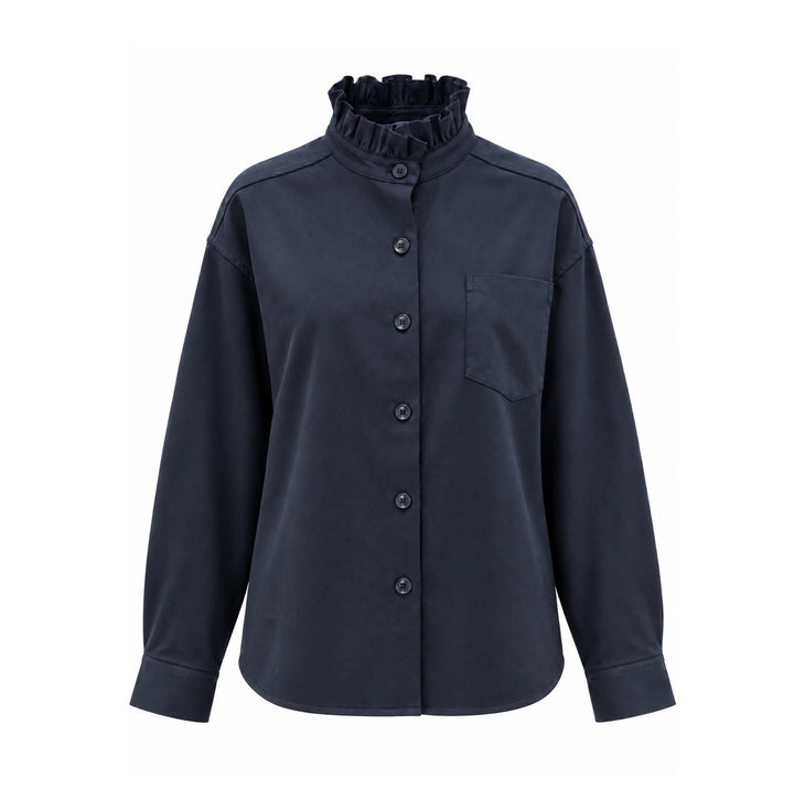 Bluse Narli in Night Blau. Aus Schurwolle mit Stretch-Anteil und mit einen femininen Rüschenkragen. Durchgehende Knopfleiste, überschnittene Schultern und aufgesetzte Brusttasche. Eine Kellerfalte auf der Rückseite.