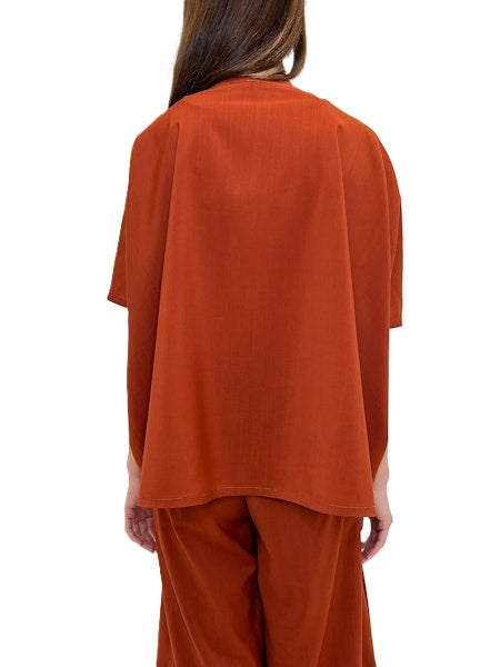 Blusenshirt von Odeeh in spice red aus einer light woo Ware mit Rundhalsausschnitt. Die bluse ist oversized und hat überschnittene Schultern und einen asymmetrischen Abschluss. Es gibt auch die passende Hose dazu. 