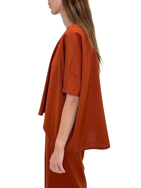 Blusenshirt von Odeeh in spice red aus einer light woo Ware mit Rundhalsausschnitt. Die bluse ist oversized und hat überschnittene Schultern und einen asymmetrischen Abschluss. Es gibt auch die passende Hose dazu. 