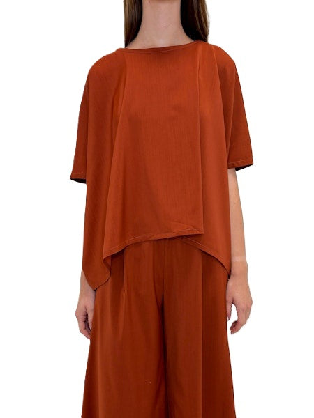 Blusenshirt von Odeeh in spice red aus einer light woo Ware mit Rundhalsausschnitt. Die bluse ist oversized und hat überschnittene Schultern und einen asymmetrischen Abschluss. Es gibt auch die passende Hose dazu. 