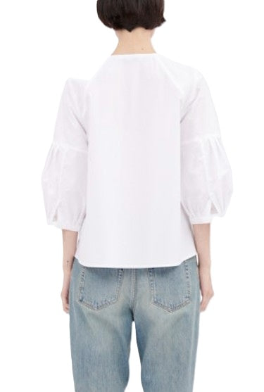 Bluse von Odeeh in weiß mit 3/4 Ärmeln und Fältelung am Ärmel. Die Bluse ist ausgestellt, hat keinen Kragen und eine Knopfleiste aus Baumwolle. 