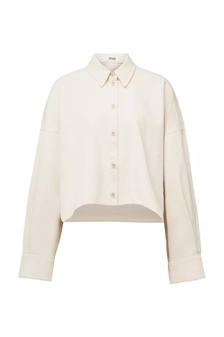 Bluse Drykorn OSHIA 10 in beige. OSHIA ist eine Oversized Hemdbluse mit überschnittener Schulter und überlangen Ärmeln. Die hübsche Bluse hat einen Kragen und eine Knopfleiste und ist vorne kürzer als hinten geschnitten. Sie ist oversized geschnitten.