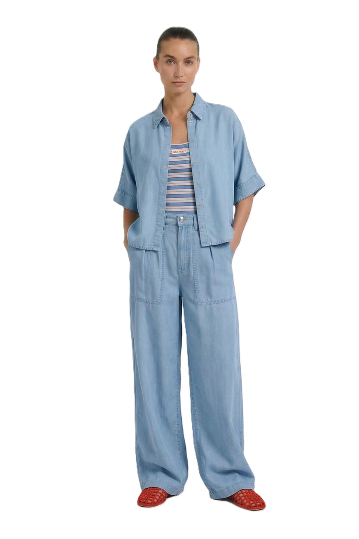 Bluse Oui. Schöne und sommerliche Halbarmbluse aus 100% Lyocell Denim. Die Bluse ist lässig geschnitten und hat eine reguläre Länge. Sie hat einen Kragen und eine Druckknopfleiste. Die Bluse hat einen weiten Kurzarm. Die Ärmel sind angeschnitten. Es befinden sich Kellerfalten links und rechts an der Rückenpasse. 