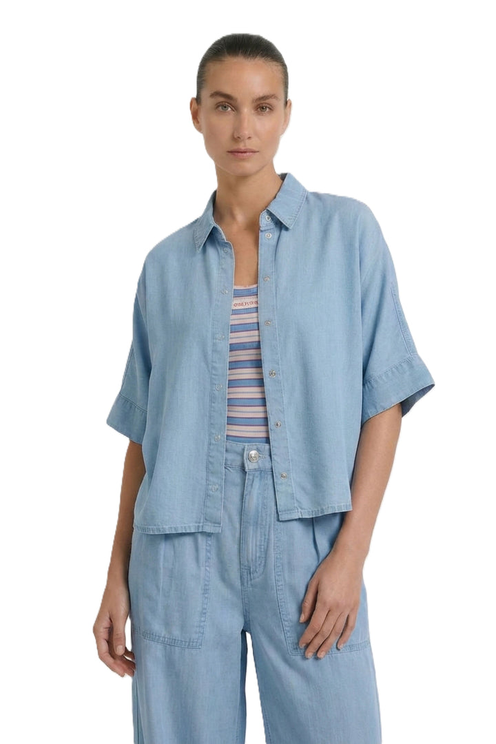 Bluse Oui. Schöne und sommerliche Halbarmbluse aus 100% Lyocell Denim. Die Bluse ist lässig geschnitten und hat eine reguläre Länge. Sie hat einen Kragen und eine Druckknopfleiste. Die Bluse hat einen weiten Kurzarm. Die Ärmel sind angeschnitten. Es befinden sich Kellerfalten links und rechts an der Rückenpasse. 