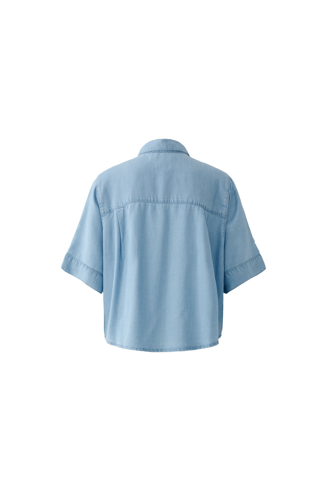 Bluse Oui. Schöne und sommerliche Halbarmbluse aus 100% Lyocell Denim. Die Bluse ist lässig geschnitten und hat eine reguläre Länge. Sie hat einen Kragen und eine Druckknopfleiste. Die Bluse hat einen weiten Kurzarm. Die Ärmel sind angeschnitten. Es befinden sich Kellerfalten links und rechts an der Rückenpasse. 