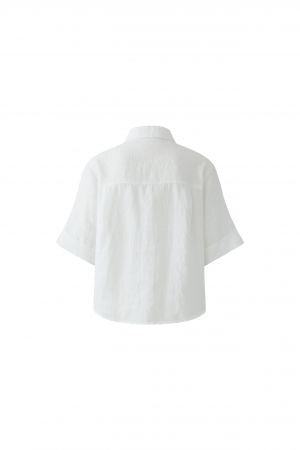 Bluse Oui. Sommerliche Leinenbluse in weiß. Die Bluse hat einen Kragen und eine Knopfleiste und ist gerade geschnitten. Die Bluse ist leicht transparent. Der Ärmel ist halblang.
