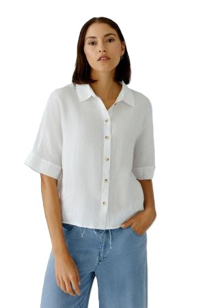 Bluse Oui. Sommerliche Leinenbluse in weiß. Die Bluse hat einen Kragen und eine Knopfleiste und ist gerade geschnitten. Die Bluse ist leicht transparent. Der Ärmel ist halblang.