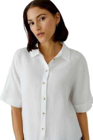 Bluse Oui. Sommerliche Leinenbluse in weiß. Die Bluse hat einen Kragen und eine Knopfleiste und ist gerade geschnitten. Die Bluse ist leicht transparent. Der Ärmel ist halblang.
