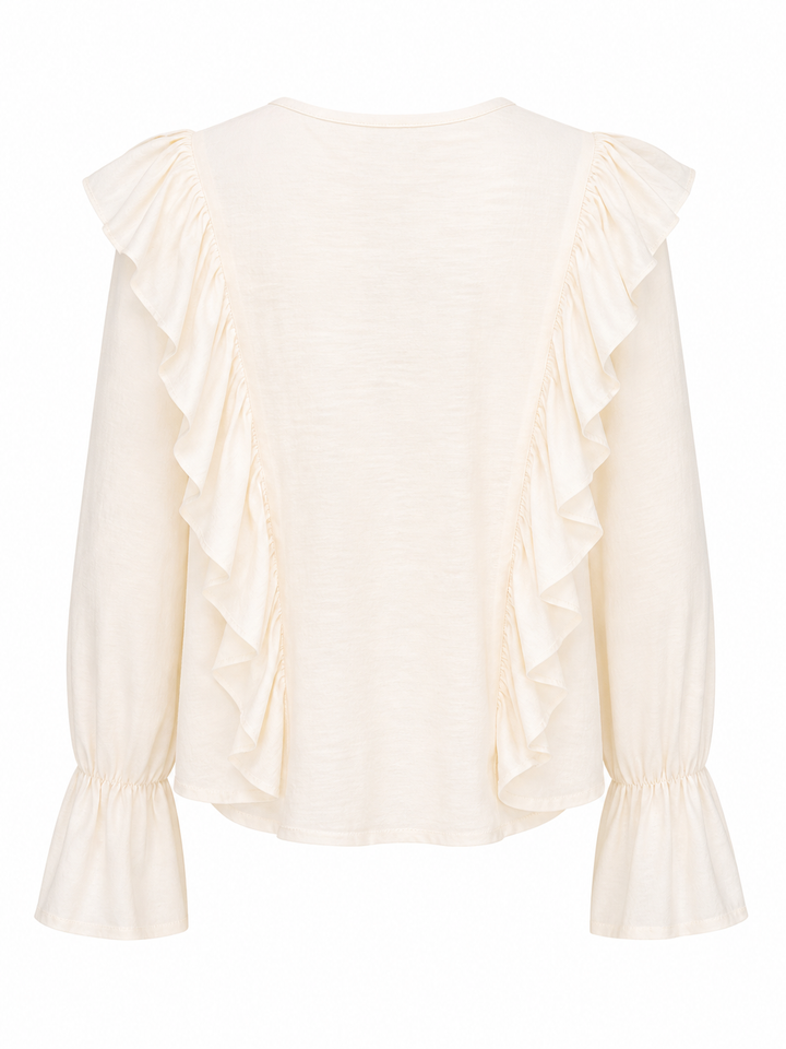 Bluse Pho Firenze in beige. Diese Bluse ist ein richtiges Highlight. Die Rüschen auf der Vorderseite sind besonders feminin und romantisch. Die Bluse hat einen tiefen V-Ausschnitt, welcher mit einem Bändchen geschlossen werden kann. Die Ärmel haben einen Gummizug und der Saum fällt leicht trompetenförmig.