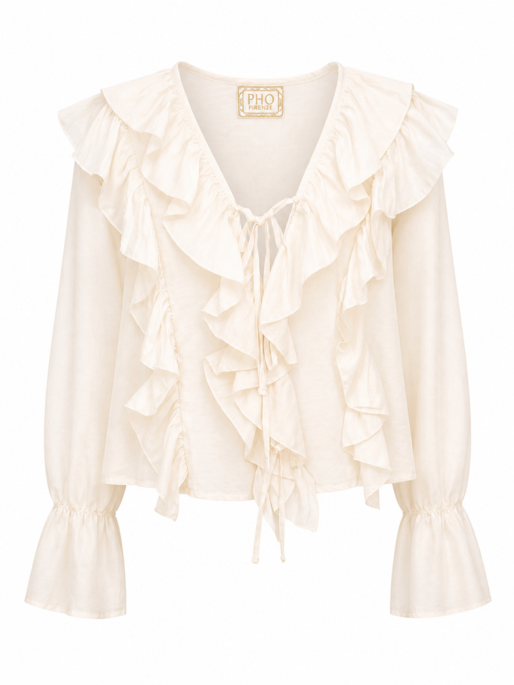 Bluse Pho Firenze in beige. Diese Bluse ist ein richtiges Highlight. Die Rüschen auf der Vorderseite sind besonders feminin und romantisch. Die Bluse hat einen tiefen V-Ausschnitt, welcher mit einem Bändchen geschlossen werden kann. Die Ärmel haben einen Gummizug und der Saum fällt leicht trompetenförmig.
