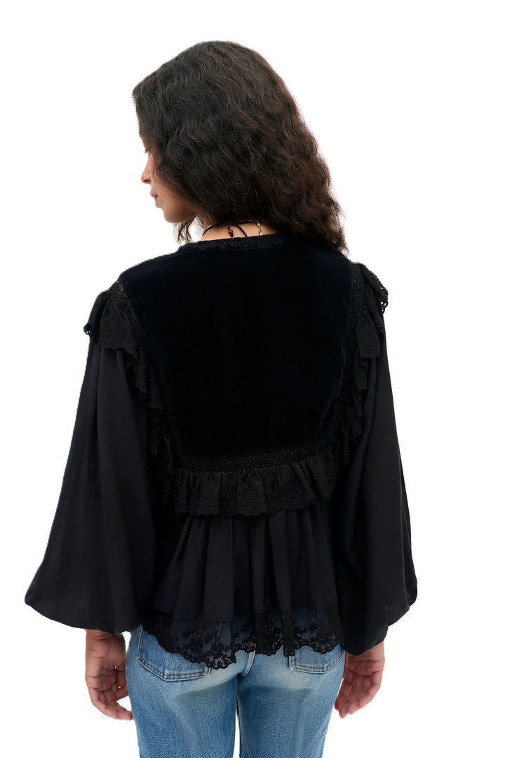 Bluse Rixo Diann Top in black. Ganz besondere Bluse in schwarz. Die Bluse hat einen verspielten romantischen Look mit Spitze und Samt. Die Bluse ist aufwendig mit Stickereien bestickt und hat kleine Spitzenflügel an den Schultern. Die Ärmel sind lang und haben eine Gummimanschette zum Hochshoppen. Sie hat einen V-Ausschnitt mit kleinen Knöpfen und Bändern mit Kordeldetails. 