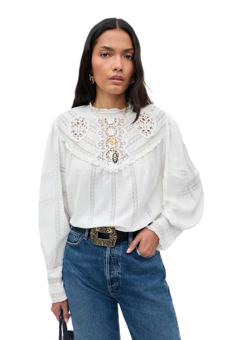 Bluse Rixo Tamzin Top in cream. Super schöne und moderne Bluse mit femininen allover Spitzendetails. Die Bluse hat Knöpfe auf der Rückseite. Sie hat einen Stehkragen und kann schön in die Hose gesteckt werden. Die Ärmel sind lang mit breiter Spitzenmanschette.