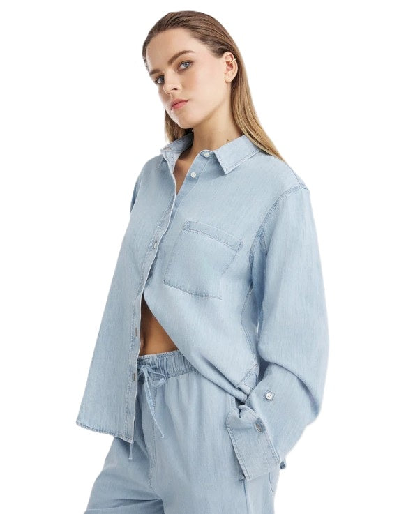Jeansbluse SO SUE Blouse Classic Denim. Die Classic Bluse in Light Blue ist dein zeitloses Denim-Piece mit modernem Twist. Gefertigt aus feinem Denim Chambray. Die Bluse hat einen leicht taillierten Schnitt und dadurch eine feminine Silhouette. Die Bluse hat eine Brusttasche, Kragen und hochwertige Knöpfe. An den Ärmeln sind zusätzlich Knöpfe angebracht, so dass man sie hochkrempeln kann.