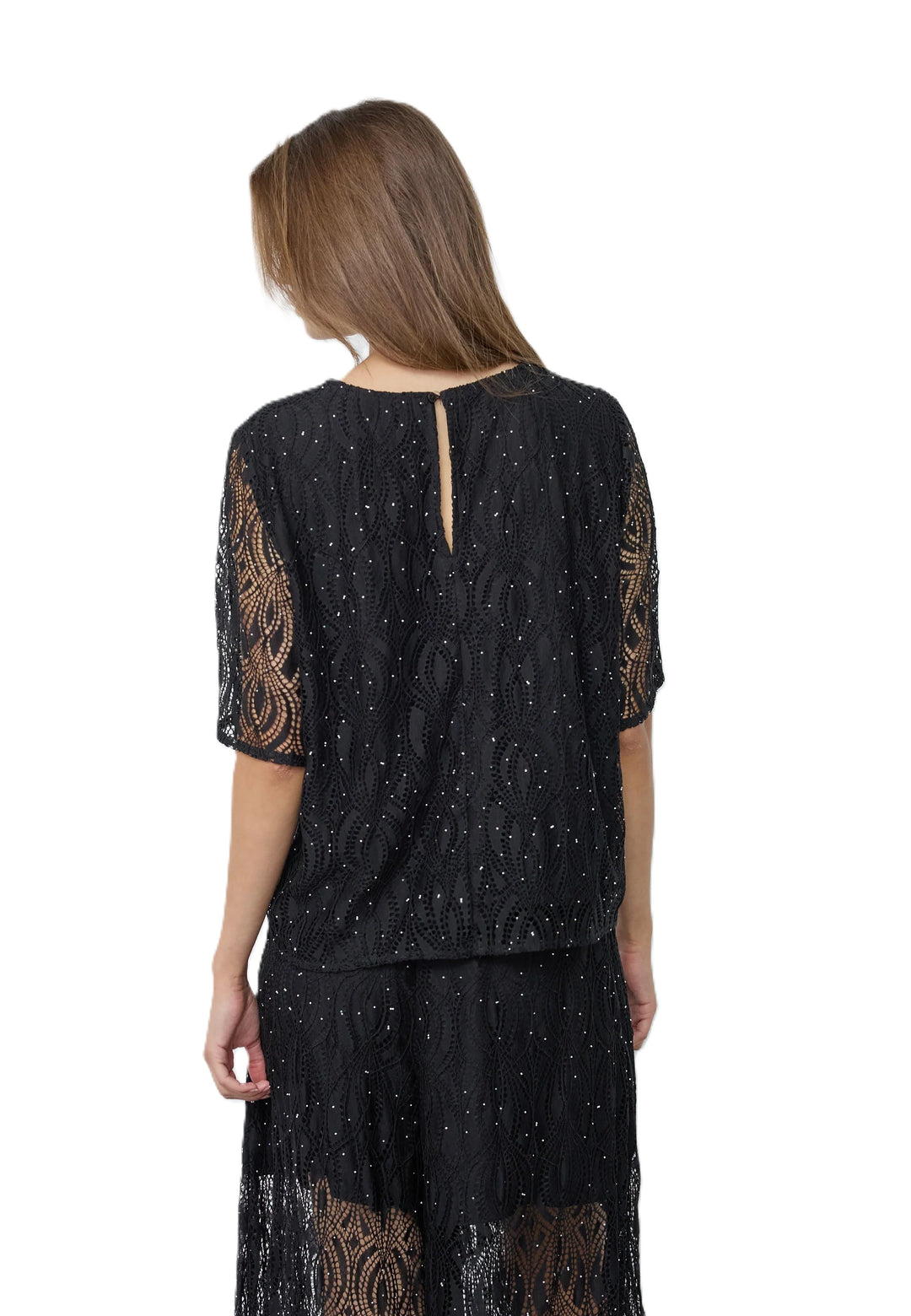 Bluse Co’Couture EricaCC in Schwarz mit lockerem Schnitt, zartem Spitzen-Lochmuster und kleinen Glitzersteinen. Der Rundhalsausschnitt, weite transparente Kurzärmel und ein Knopfverschluss mit kleinem Schlitz im Nacken unterstreichen das feminine, elegante Design.