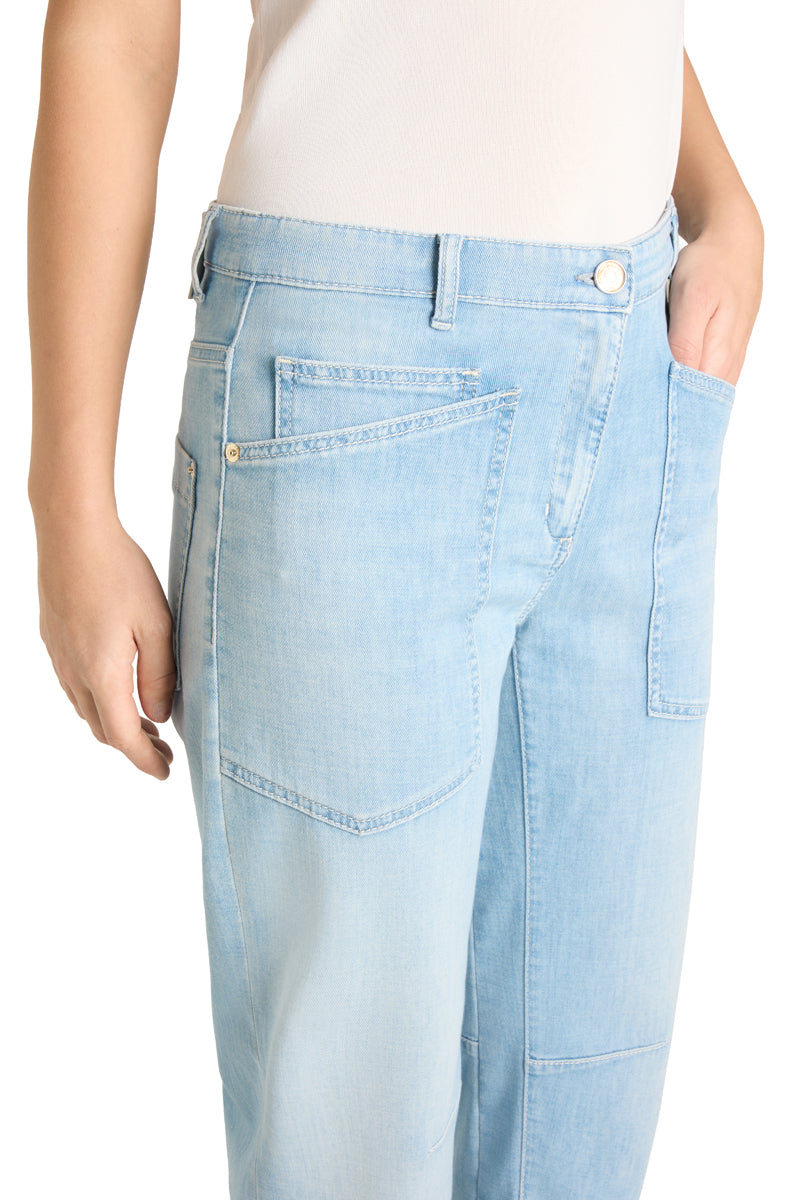 Jeans Cambio Ocean. Coole Jeans von Cambio in einem helleren Blauton. Die Waschung ist leicht verwaschen. Die Jeans hat zwei große Taschen auf der Vorderseite, einen Zip und einen Knopfverschluss. Die Jeans ist leicht konisch geschnitten, das heißt, dass sie nach unten gehend etwas schmäler wird. Das Bein ist verkürzt. Zwei Nähte an den Knien verstärken den modernen Look.