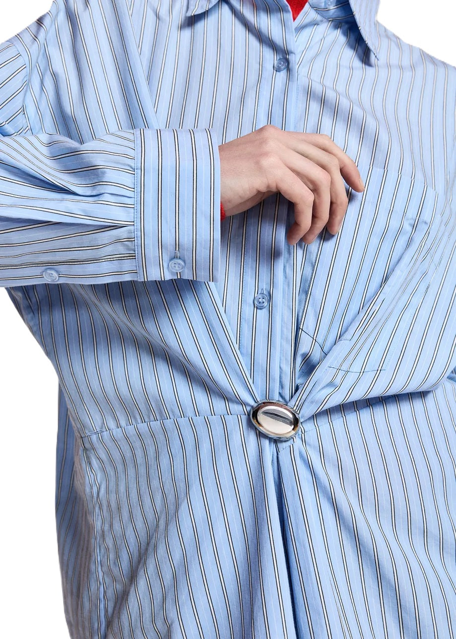 Bluse ESSENTIEL ANTWERP Kreative in blau. Gestreifte Bluse aus Baumwolle mit lässiger Oversized-Silhouette, tief angesetzten Schultern und voluminösen Ärmeln. Abgerundete Nahtpartien, eine Brusttasche, Knopfleiste mit Knopfmanschetten und eine abnehmbare Brosche.
